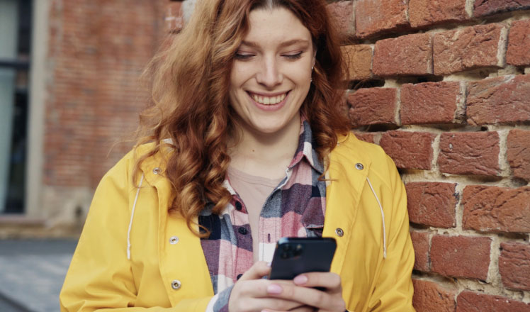 Young ginger woman watching a Pismo's platform explainer video on her mobile phone